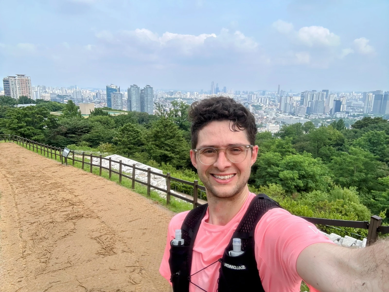 Quintin running on the Seoul City Wall trail on Namsan with the city behind him