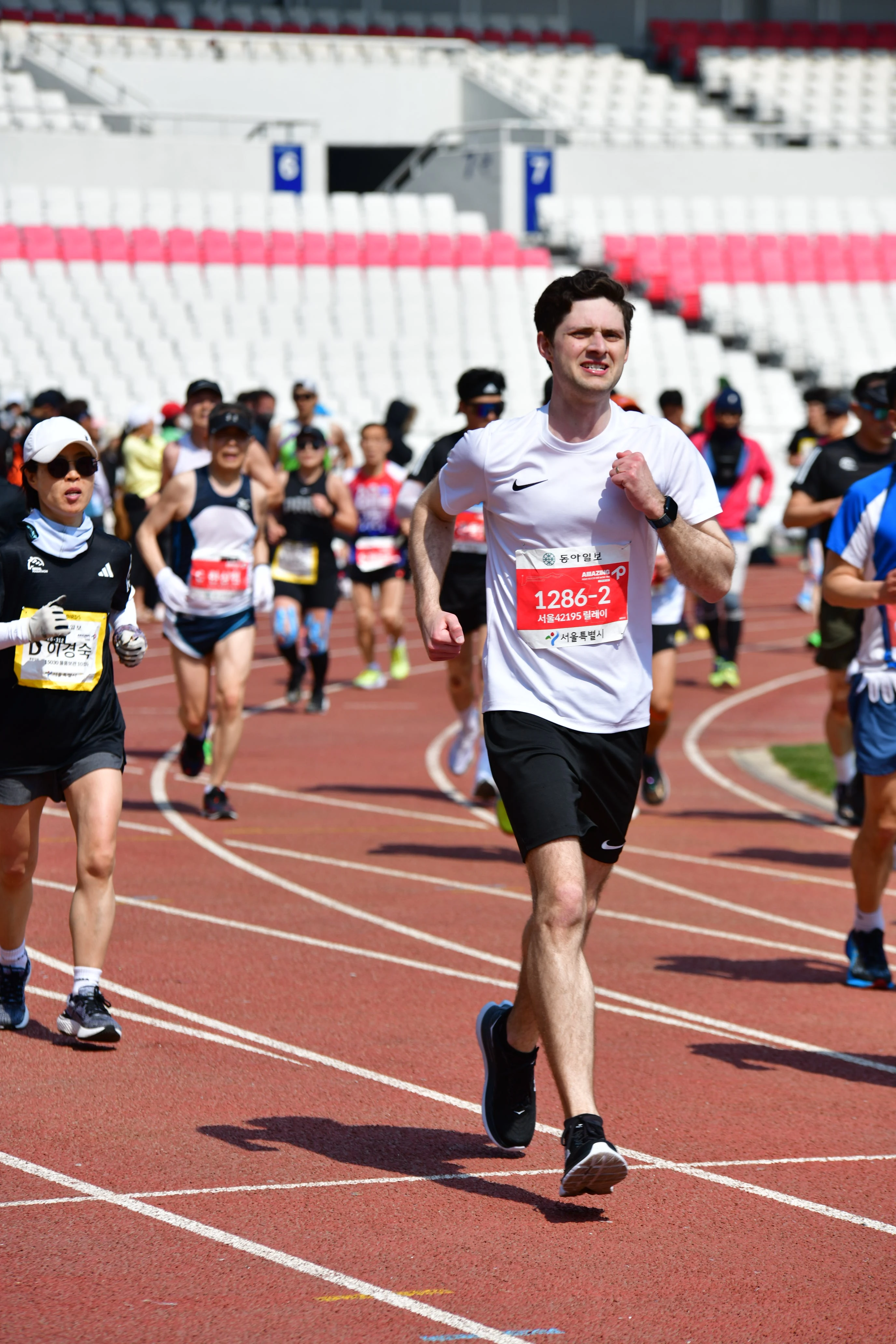 Runners finishing the Seoul Marathon inside Jamsil Olympic Stadium.